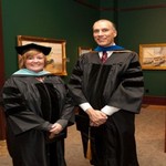 Two faculty members pose in regalia together